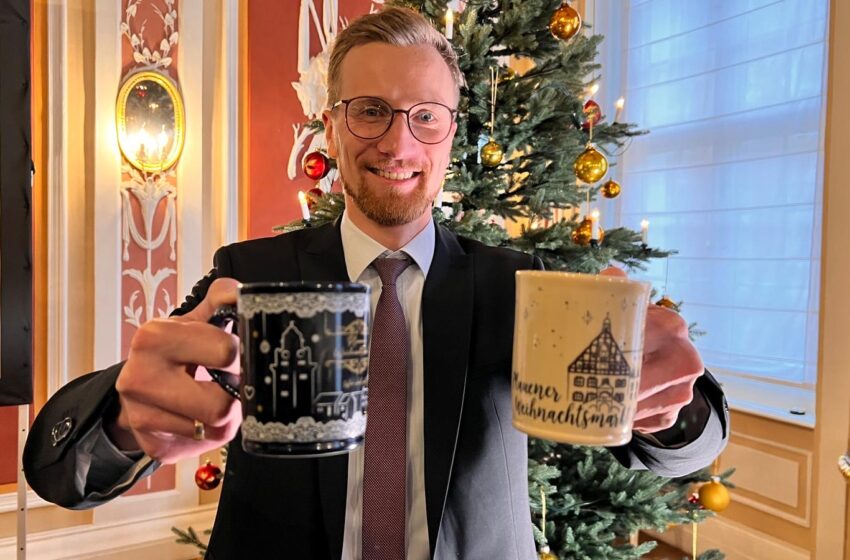 Bürgermeister Tobias Kämpf präsentiert die neuen Tassen für den Plauener Weihnachtsmarkt. Foto: s. Höfer