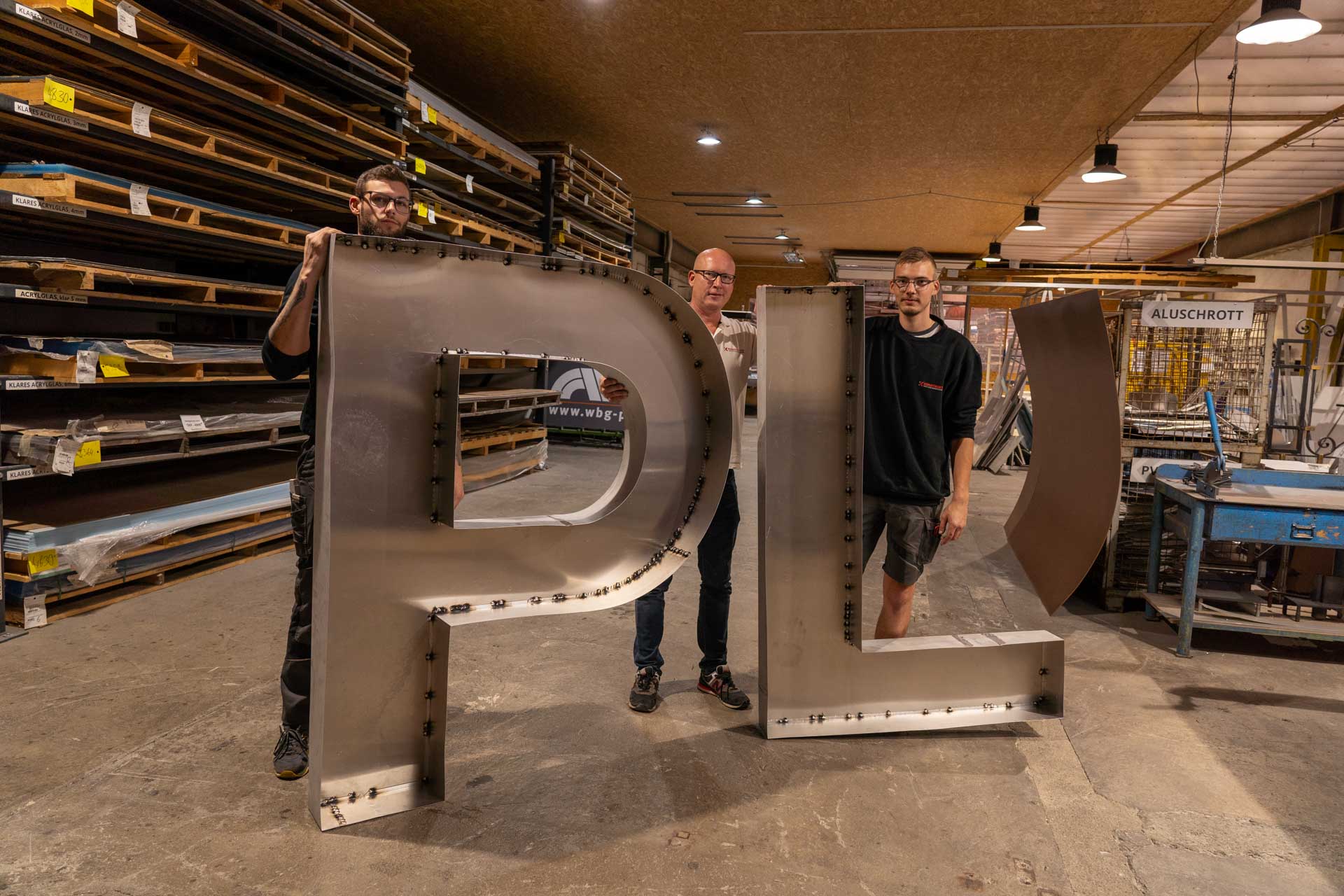 René Schaarschmidt (Mitte) präsentiert mit seinen Mitarbeitern einen großen PL-Rahmen. Hier werden hunderte Kerzen ein PL zum leuchten bringen. Foto: D. Kamerknecht